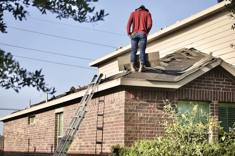 Professional roofer working on a residential roof in Yalecrest